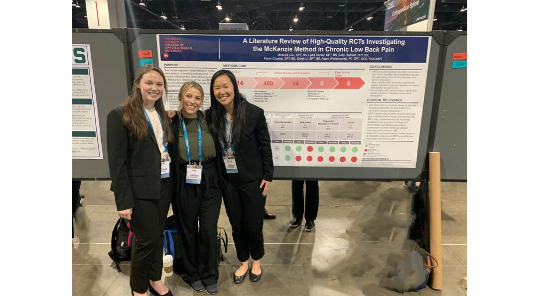 Students standing in front of their poster