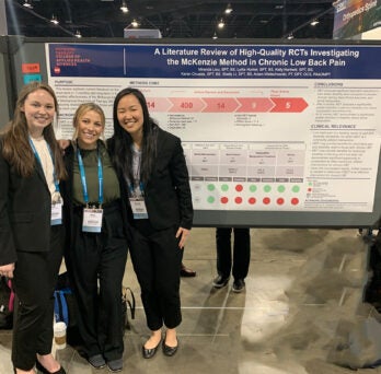 Students standing in front of their poster
                  