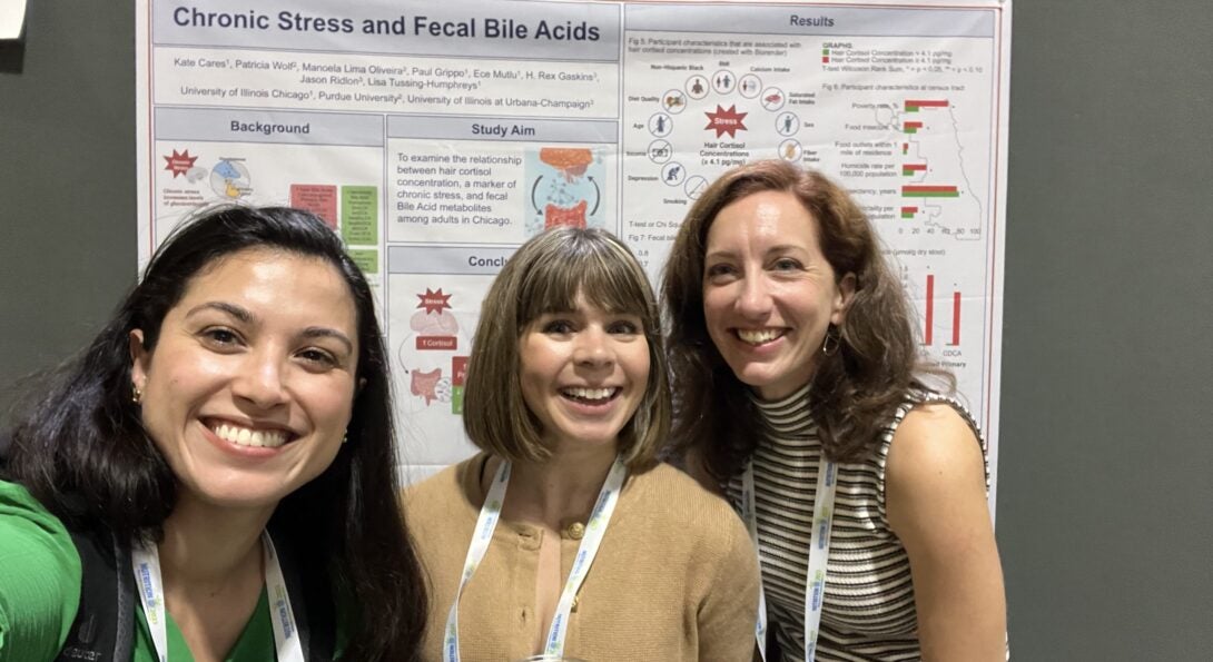 Manoela Lima Oliveira, Brittany Dipiazza and Kate Cares in front of the winning poster in the Emerging Leaders in Nutrition poster award competition.