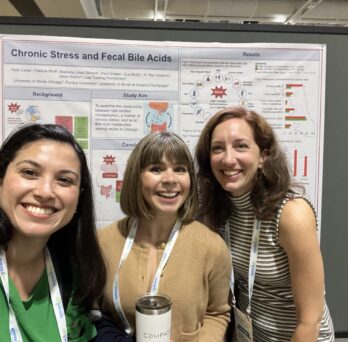 Manoela Lima Oliveira, Brittany Dipiazza and Kate Cares in front of the winning poster in the Emerging Leaders in Nutrition poster award competition.
                  