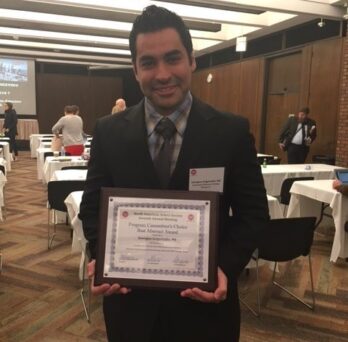 Georgios Grigoriadis holding his NAA award certificate
                  