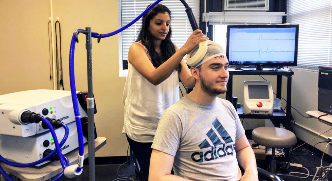 Woman scans a seated man's brain