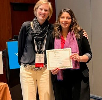 Tanvi Bhatt stands while holding 2024 John P. Maley Award
                  