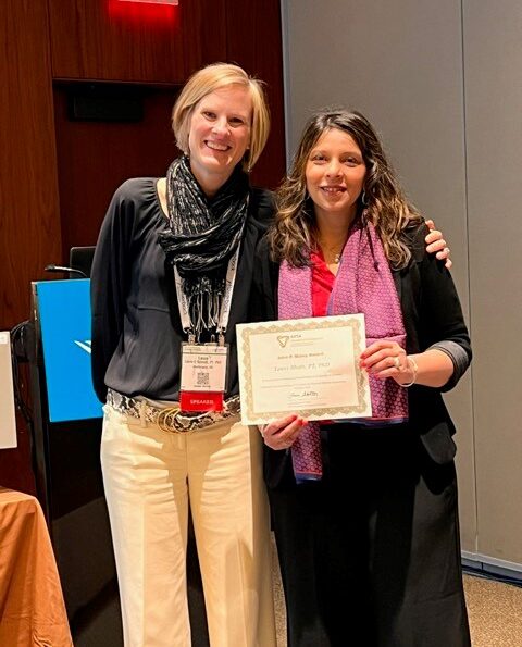 Tanvi Bhatt stands while holding 2024 John P. Maley Award